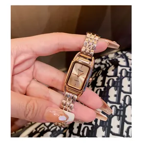Close-up of Dinimi rose gold rectangular quartz watch with steel link strap