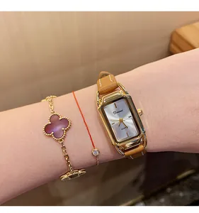 Close-up view of a Dimini minimalist vintage rectangular gold watch with brown leather strap
