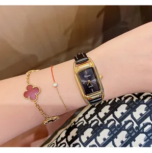Detail shot of Dimini vintage square gold watch on female wrist with black strap