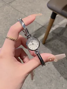 GEDI minimalist silver bracelet watch with an exquisite small round dial held in hand
