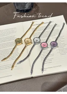 Orologi al quarzo GUOU piccoli ed eleganti in vari colori su un libro