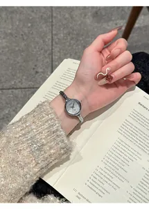 Primo piano dell'orologio al quarzo GUOU argento minimalista su un polso femminile.