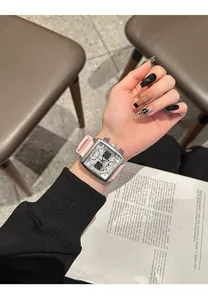 Primer plano de un elegante reloj cronógrafo cuadrado con correa de silicona rosa