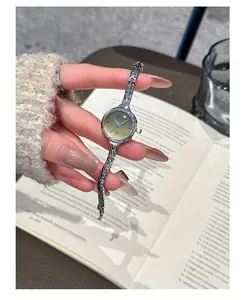Primo piano dell'elegante piccolo orologio al quarzo GUOU argento con quadrante dorato e cinturino