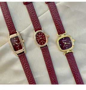 Detail view of three retro women's watches with burgundy leather straps and gold cases
