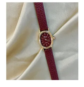 Close-up of vintage Angola red ladies watch with gold oval dial on satin