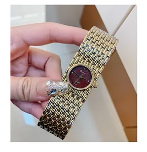 Detailed macro view of Dinimi vintage gold bracelet watch featuring deep red dial