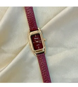 Macro view of vintage Ankara red watch with gold rectangular case and leather strap