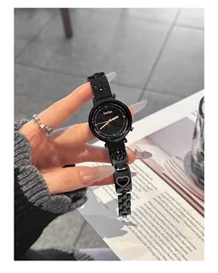 Elegante schwarze Stahluhr mit Herz- und Welpenmotiven, in der Hand präsentiert