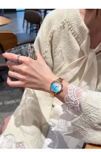 Elegant Eavanlin watch with blue gradient dial on woman's wrist with gold mesh strap
