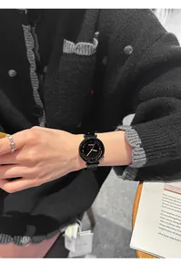 Detailansicht einer stilvollen schwarzen Edelstahluhr für Damen an einem Handgelenk