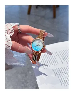 Detailed view of EAVANLIN rose gold watch featuring a gradient blue dial and mesh band