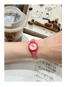 Detailed view of a small cute pink round wristwatch worn on a woman's slender wrist