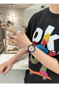 Close-up of a colorful cartoon watch with red silicone strap and star pattern dial.