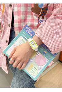 Primer plano de un lindo reloj rectangular blanco y amarillo para estudiantes en la muñeca