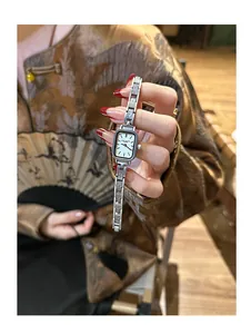 Detailansicht einer rechteckigen silbernen Quarzuhr im Vintage-Stil mit Gliederarmband