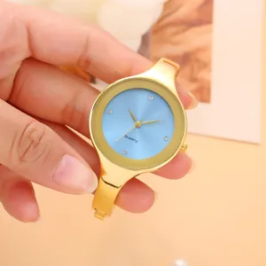 Primo piano di un elegante orologio a bracciale dorato con quadrante blu e punti luce