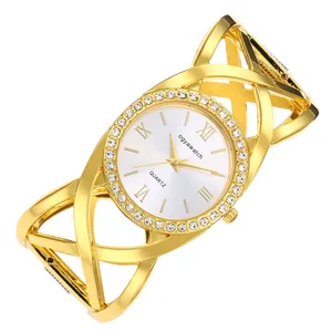 Detailed view of a vintage gold bangle watch featuring cross-line design and rhinestones