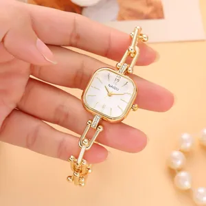 Nahaufnahme der goldenen Kettenuhr mit quadratischem Zifferblatt und Diamanten