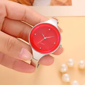 Dettaglio di un elegante orologio a bracciale da donna in argento con quadrante rosso vivace