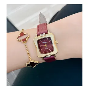 Detailed close-up of a retro Angola red women's watch with a gold casing and clover bracelet.