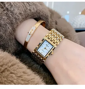 Close-up van gouden horloge met vierkante wijzerplaat en luxe armband