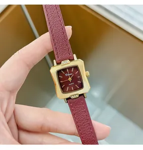 Detailed macro view of a vintage red leather strap watch with a gold square dial