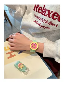 Detail of a preppy style silicone watch with a fun burger illustration on the pink dial