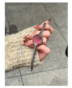 Vista dettagliata di un piccolo orologio al quarzo GUOU con quadrante rosso e cinturino a catena