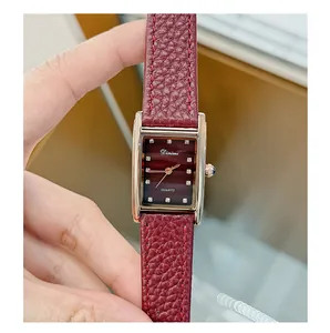 Macro detail of retro Angola red women watch with vintage gold rectangular dial and leather strap