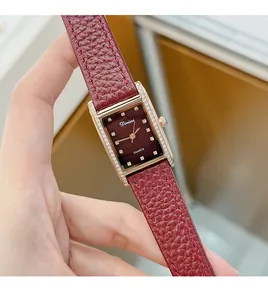 Close-up detail of a vintage red rectangular women's watch with crystal markers and leather strap