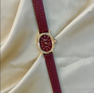 Elegant vintage-style women's watch with burgundy leather strap and oval gold case