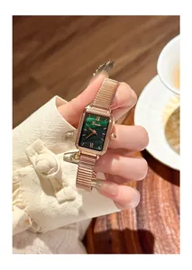 Close-up of a vintage rectangular watch featuring a malachite green dial and rose gold strap