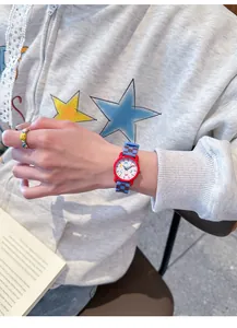 Detailopname van een kleurrijk kinderhorloge met een blauwe geruite siliconen band om pols
