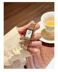 Close-up showing the elegant white marble dial of this gold square quartz watch