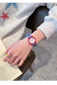 Detail van een vrolijk kinderhorloge met rode lunette en blauw geblokte siliconen band