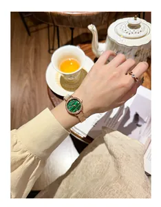 Close-up of elegant women's watch with green malachite dial and rose gold band