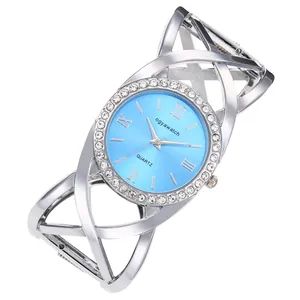 Macro view of retro bangle watch featuring criss-cross silver band and light blue dial.