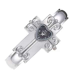 Dettaglio dell'orologio a bracciale a croce argento con quadrante nero a cuore.