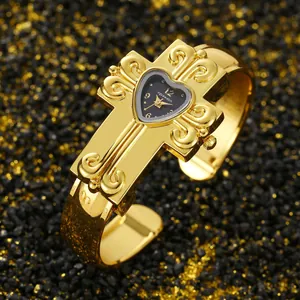 Vista dettagliata di un orologio a bracciale a croce d'oro con quadrante a cuore
