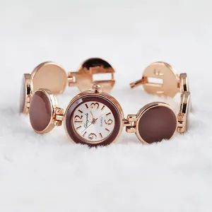 Vista dettagliata di un elegante orologio a bracciale in oro rosa con inserti circolari marroni