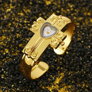 Primo piano di un orologio a bracciale con croce d'oro vintage e quadrante a cuore