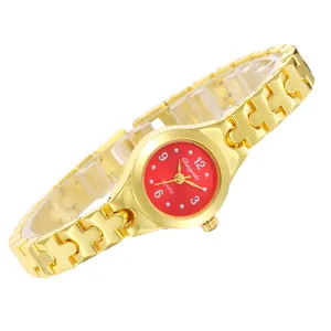 Detail van een elegant gouden armbandhorloge met een rode wijzerplaat en puzzelstukjes
