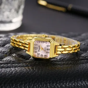 Dettaglio di un elegante orologio a bracciale dorato con quadrante quadrato rosa.
