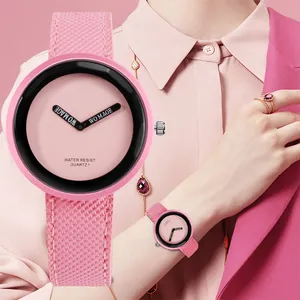 Dettaglio dell'orologio rosa alla moda con quadrante grande e cinturino intrecciato
