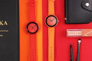 Vista dei dettagli di orologi al quarzo minimalisti con quadrante grande rosso e arancione.