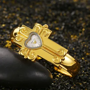 Vista dettagliata del quadrante a forma di cuore e del design a croce dorata di questo orologio