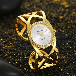 Detailed view of a gold retro bangle watch with criss-cross straps and rhinestone bezel