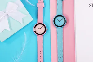 Primo piano di orologi al quarzo minimalisti rosa e blu con cinturini intrecciati.