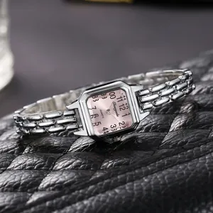 Dettaglio di un orologio a bracciale argento da donna con quadrante rosa quadrato
